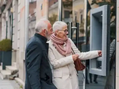 یک خانم و اقای مسن جلوی باجه بانک
