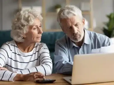خانم و اقای مسن که با لپ تاپ کار می کنند.