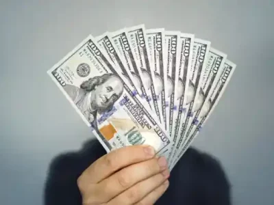 تعدادی دلار در دست یک فرد